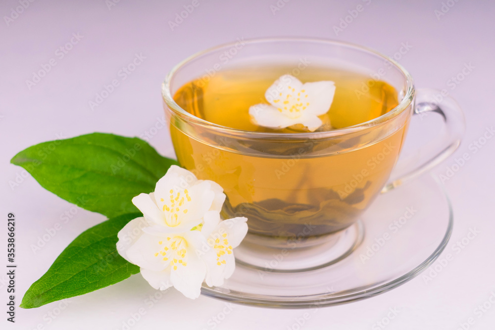 Cup of jasmine tea and jasmine flowers on a white background.Close-up Cup of jasmine tea and jasmine flowers on a white background.Close-up