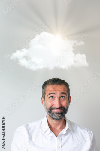 portrait of man smiling to a cloud and sunrays overhead