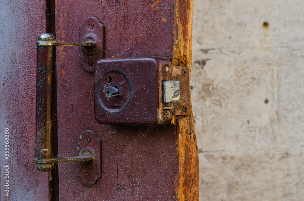 Close-up, old lock on a red wooden door Close-up, old lock on a red wooden door