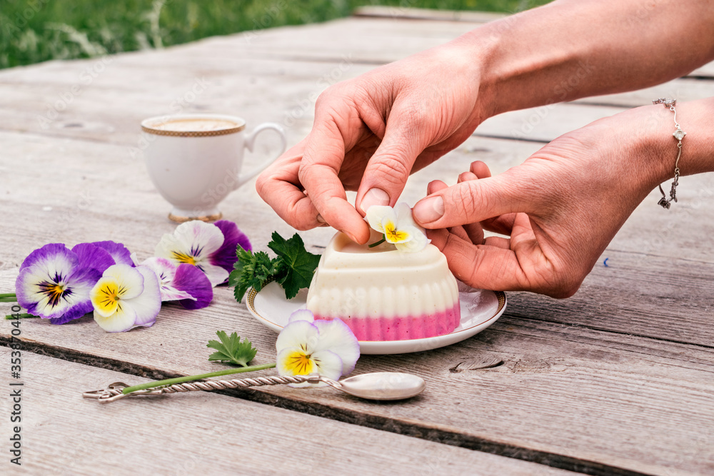 Woman's hand adorns a heart shaped curd souffle with a flower.Сoncept of healthy food and healthy handmade dessert.The al fresco dining Woman's hand adorns a heart shaped curd souffle with a flower.Сoncept of healthy food and healthy handmade dessert.The al fresco dining