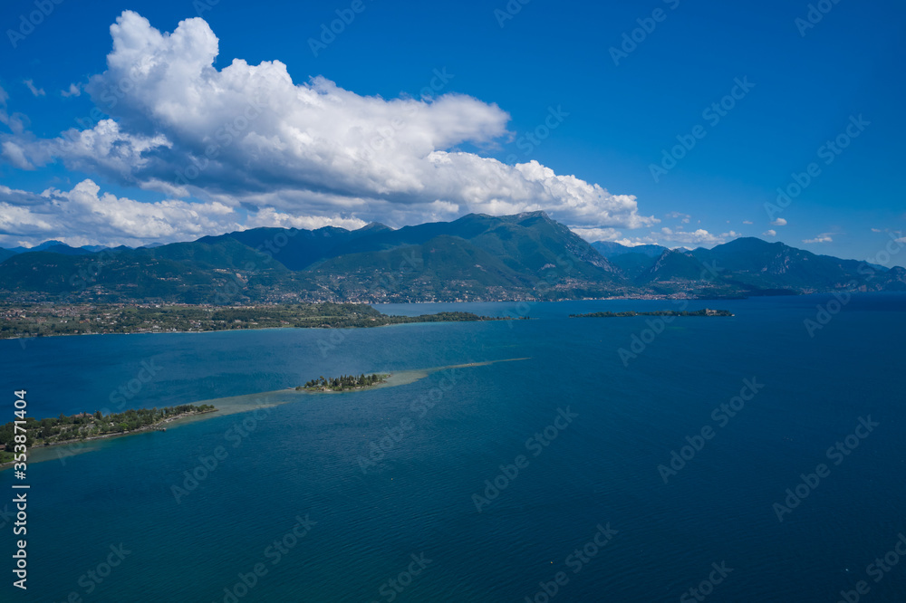 Lake Garda, Italy. Panoramic aerial view of garda island, san biagio island in the background alpine mountains