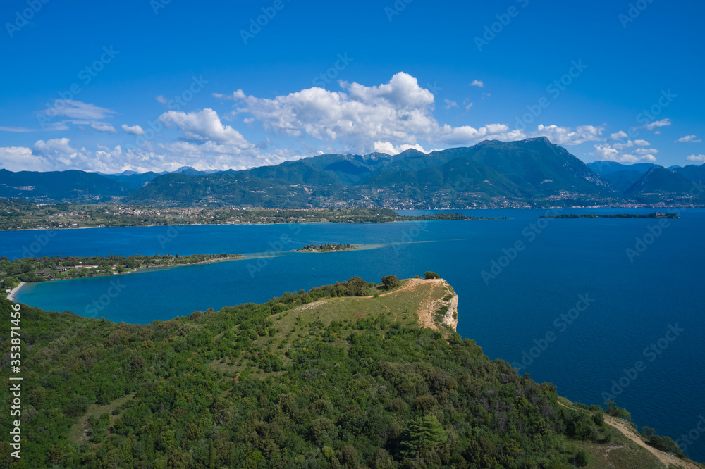 Lake Garda, Italy. Aerial view of punta sasso, rocca di manerba in the background mountains, san biagio island, garda island at high altitude