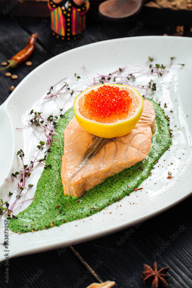 Salmon fillet spinach sauce lemon red roe caviar 