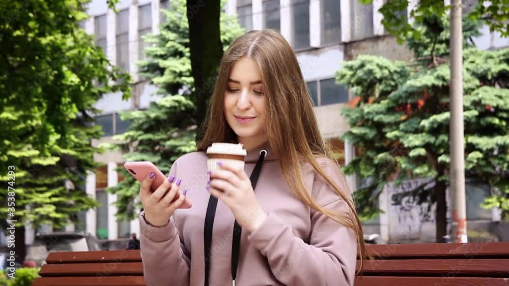 Young blond woman with coffee chatting on mobile phone sitting on the bench in park. Young blond woman with coffee chatting on mobile phone sitting on the bench in park.