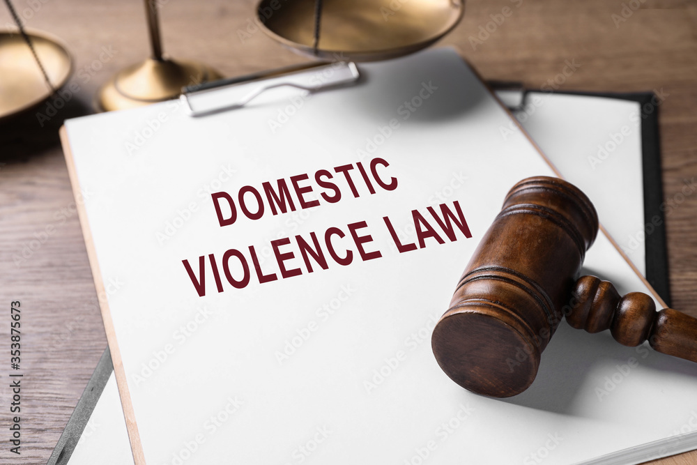 Clipboard with words DOMESTIC VIOLENCE LAW and gavel on wooden table Clipboard with words DOMESTIC VIOLENCE LAW and gavel on wooden table