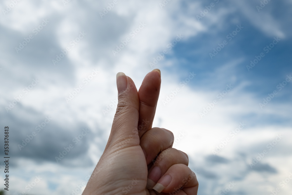 Woman making a mini heart-shaped with her hands on blue sky and cloud background Woman making a mini heart-shaped with her hands on blue sky and cloud background