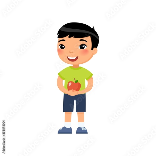 Cute boy holding apple flat vector illustration. Little asian child and little fruit. Happy preteen kid standing with summer crop cartoon character isolated on white background