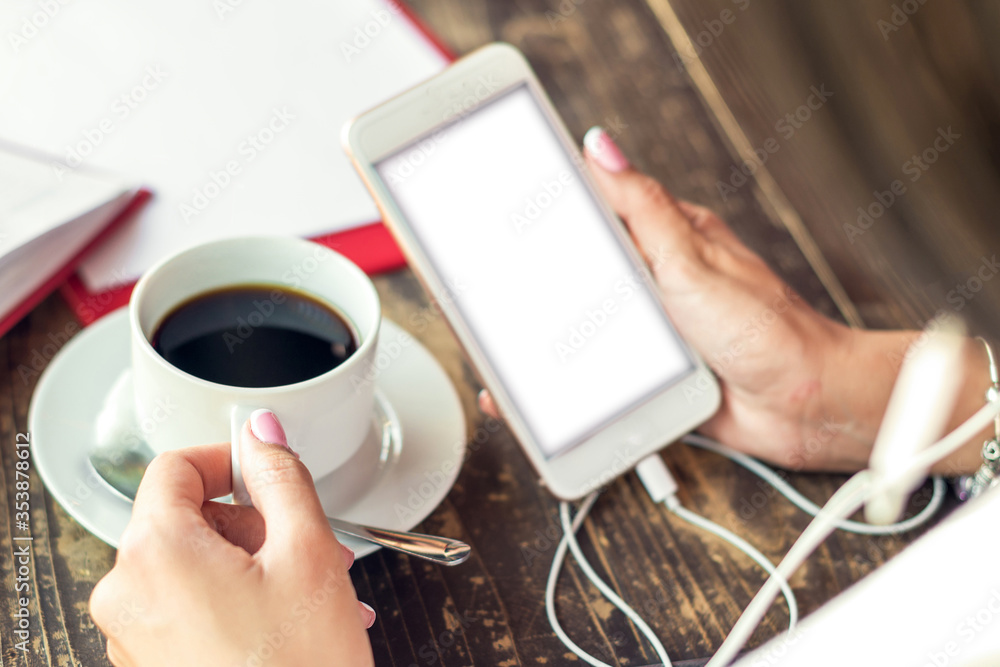 Hand of woman holding smart phone with white screen at cafe. Mockup white screen. Hand of woman holding smart phone with white screen at cafe. Mockup white screen.