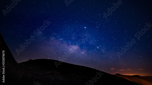 Panoramaufnahme des Sternhimmels mit Milchstraße über Hügellandschaft