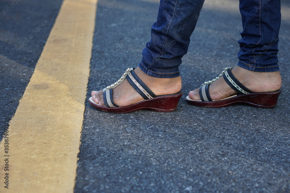 woman's foot on the yellow line of the road woman's foot on the yellow line of the road
