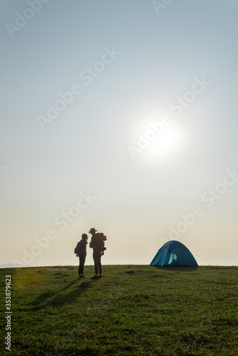 Couple with a tent on top of mountain