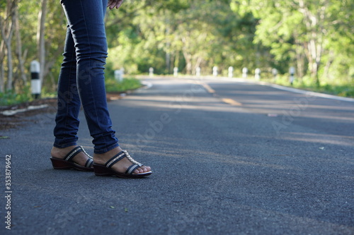 woman's foot on the yellow line of the road © buraratn