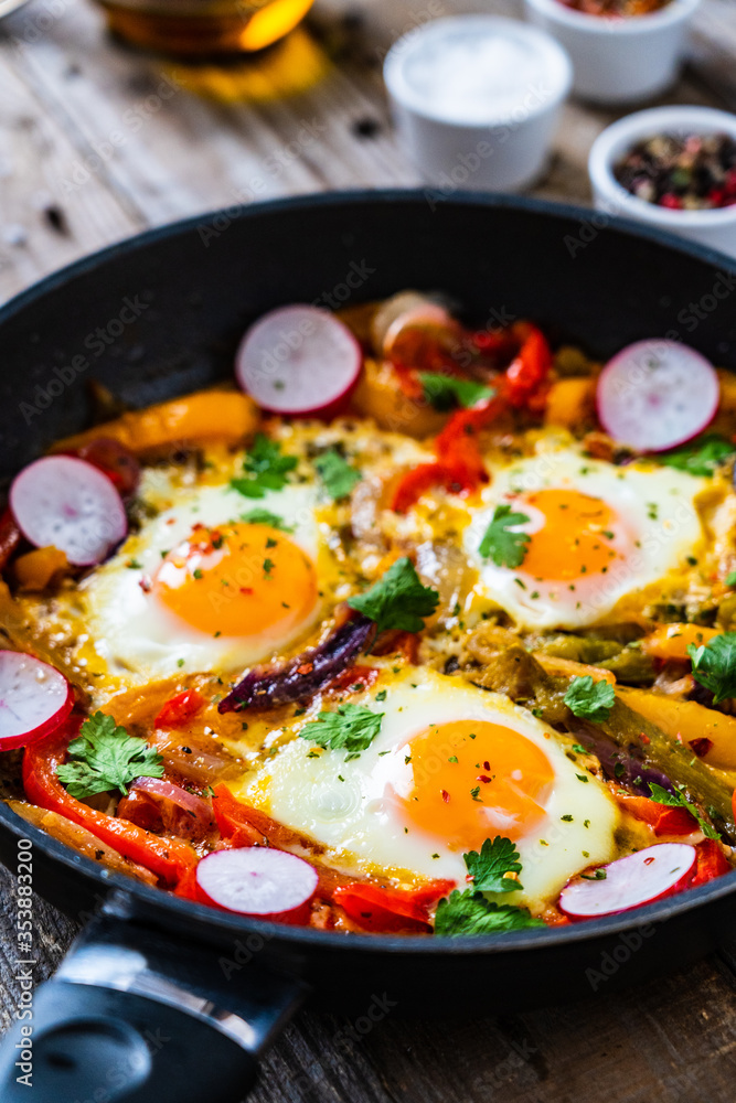 Shakshuka - fried eggs with vegetables in frying pan
Shakshuka - fried eggs with vegetables in frying pan