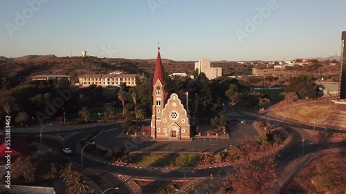 4K aerial drone summer sunset video of Windhoek old vintage Christuskirche red roof and sand stone Lutheran church in city center in Namibia's capital in central highland of Namibia, southern Africa