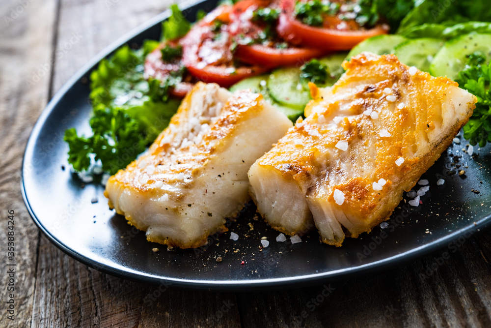 Fish dish - fried cod fillet with vegetables on wooden table
Fish dish - fried cod fillet with vegetables on wooden table