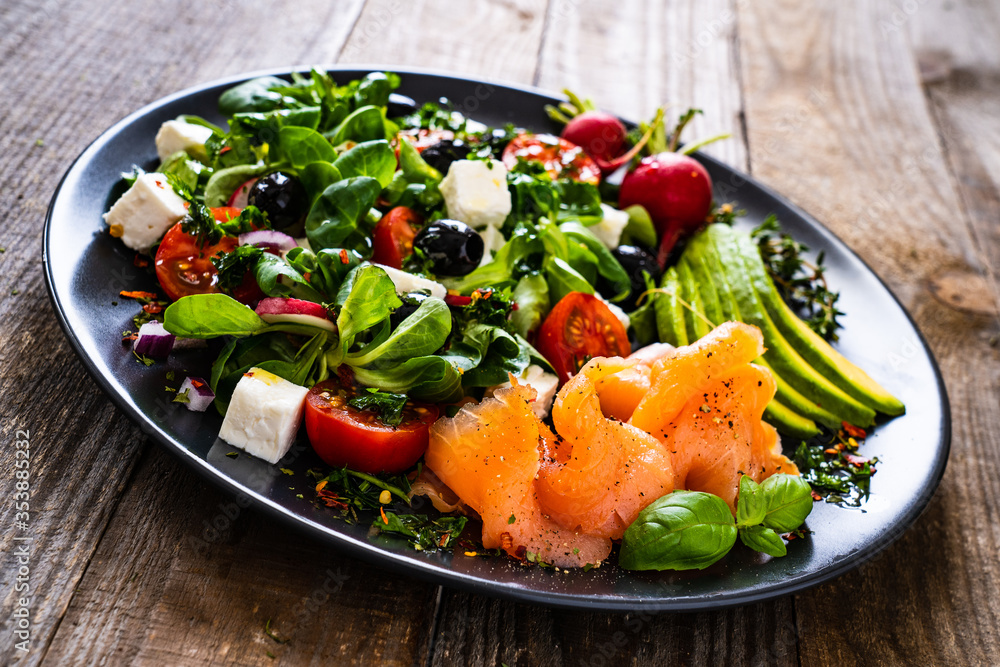 Breakfast - smoked salmon, feta cheese, avocado and vegetable salad on wooden table
Breakfast - smoked salmon, feta cheese, avocado and vegetable salad on wooden table