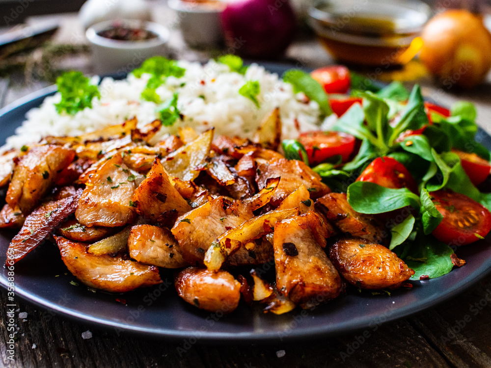 Chicken meat with rice and vegetables on wooden table
Chicken meat with rice and vegetables on wooden table