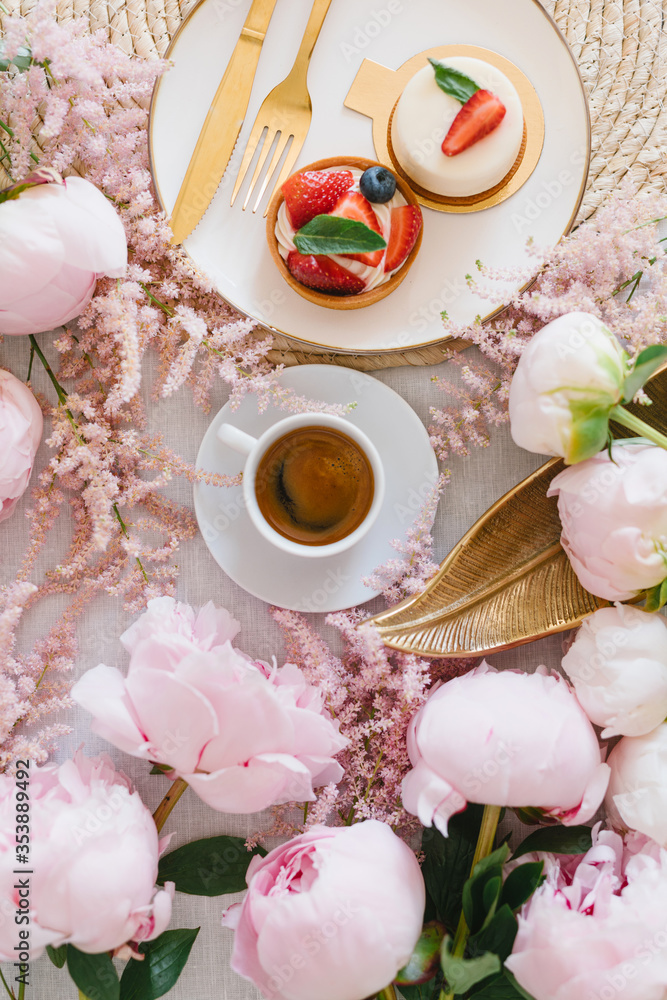 A cup of coffee, berry tartlet with fresh berries and peonies. Flat lay, composition. Coffee, dessert and flowers. Concept of coffee shop, cafe and flower shop. A cup of coffee, berry tartlet with fresh berries and peonies. Flat lay, composition. Coffee, dessert and flowers. Concept of coffee shop, cafe and flower shop.
