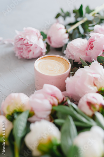 Coffee and flowers. Stylish composition of cappuccino and peonies.