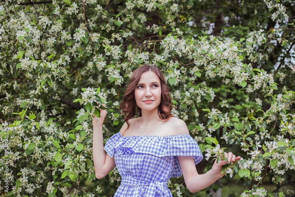 Beautiful girl in a blooming garden in spring on a Sunny day Beautiful girl in a blooming garden in spring on a Sunny day