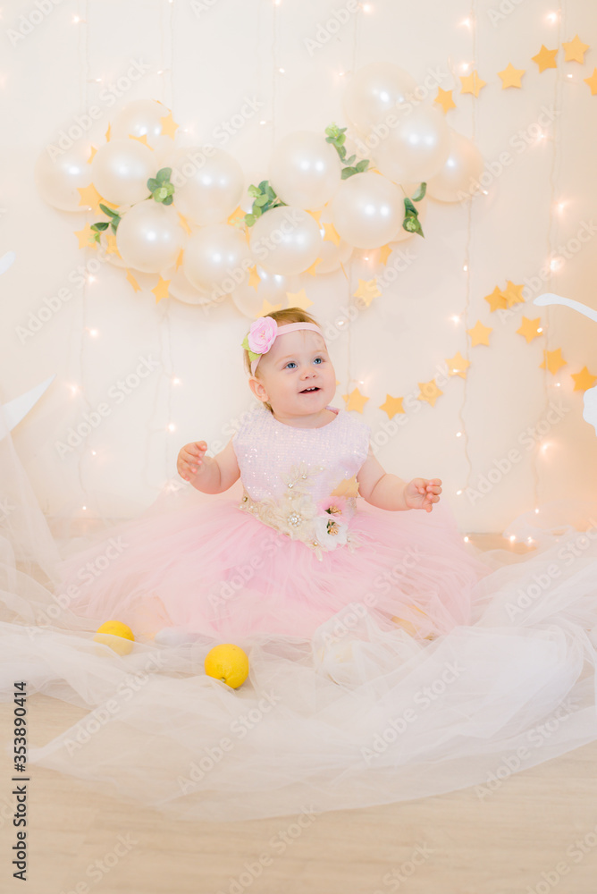 Cute little girl in a pink princess dress with a flower on her hair plays with wooden ballerinas among the golden stars on the background of a large white wooden moon and balloons. Children's decor.
Cute little girl in a pink princess dress with a flower on her hair plays with wooden ballerinas among the golden stars on the background of a large white wooden moon and balloons. Children's decor.