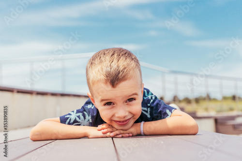 Boy in the summer against the sky in a beautiful T-shirt with palm trees