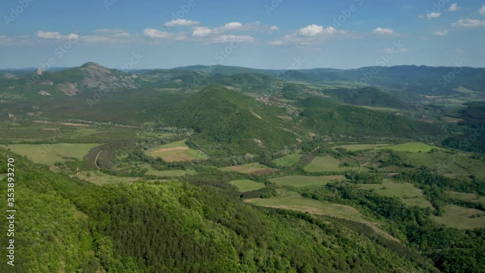 Aerial video flying over green meadows, forests and hills overgrown with lush vegetation in the spring time. The picturesque valley between hills of Eastern Balkan Mountains. Aerial video flying over green meadows, forests and hills overgrown with lush vegetation in the spring time. The picturesque valley between hills of Eastern Balkan Mountains.