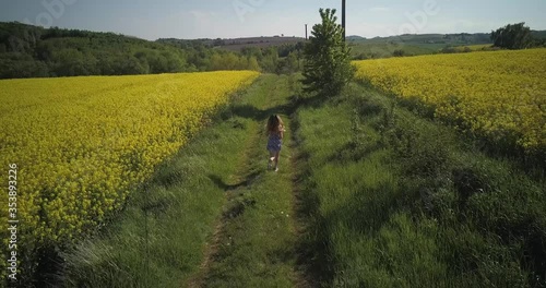 The girl runs across the field,canola field,girl running on rapeseed field
