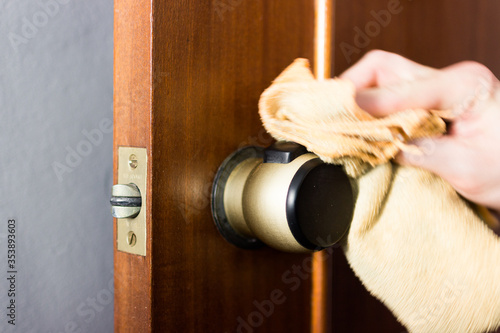 Coronavirus COVID-19 Man cleaning the button with an antibacterial disinfectant to kill the coronavirus on touching surfaces or touch the handle of the public toilet with tissue