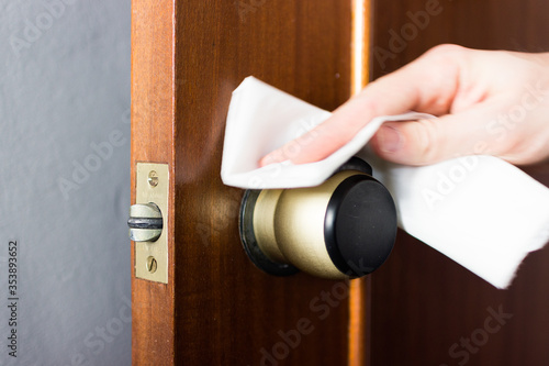 Coronavirus COVID-19 Man cleaning the button with an antibacterial disinfectant to kill the coronavirus on touching surfaces or touch the handle of the public toilet with tissue