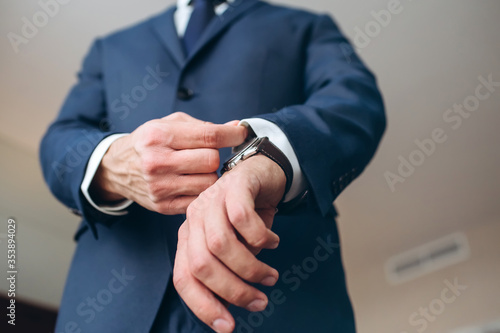 stylish groomsmen helping happy groom getting ready in the morning for wedding ceremony. luxury man in suit in room. wedding day.