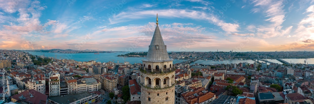 Panoramic view of Galata Tower and Istanbul Bosphorus with a cloudy sky.