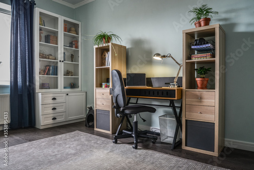 Light cozy teen room with white bookcases and working desk