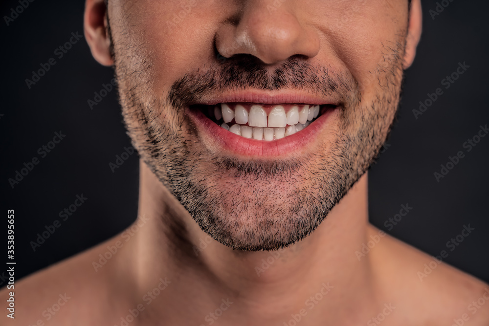 Handsome young bearded man isolated. Cropped image of shirtless muscular man is standing on grey background and smiling. Close-up of men face. Handsome young bearded man isolated. Cropped image of shirtless muscular man is standing on grey background and smiling. Close-up of men face.