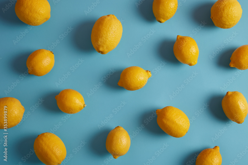 Whole yellow lemons full of vitamins and antioxidants, have sour taste, isolated over blue studio background. Essential ingredient for your nutrition. Useful peel containing bioactive compounds Whole yellow lemons full of vitamins and antioxidants, have sour taste, isolated over blue studio background. Essential ingredient for your nutrition. Useful peel containing bioactive compounds
