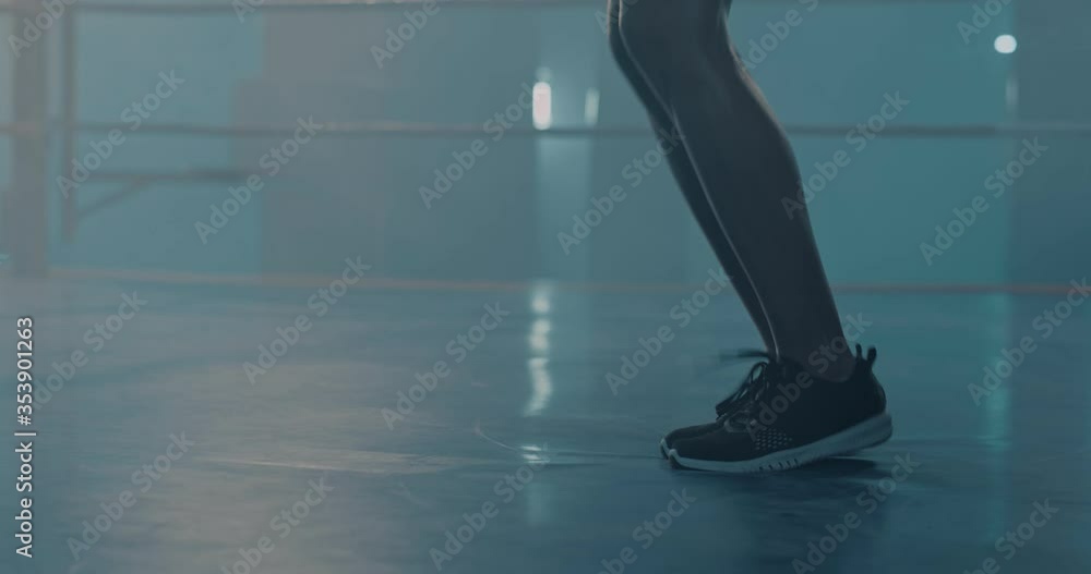 Close up of female feet in trainers jumping over rope in boxing ring. Warming up concept. Exercising for nice slim legs. Box workout concept Close up of female feet in trainers jumping over rope in boxing ring. Warming up concept. Exercising for nice slim legs. Box workout concept
