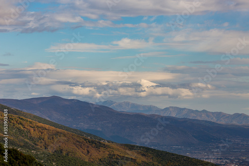 Sky with beautiful puffy white clouds and picturesque mountains, late autumn day in Northern Greece, Xanthi region, high angle colorful naturalistic view