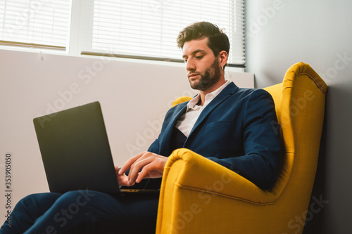 young business man in the blue jacket works using the computer in a modern office