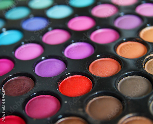 Professional multicolor eyeshadow make up palette background, close-up. Colorful bright eye shadows set backdrop