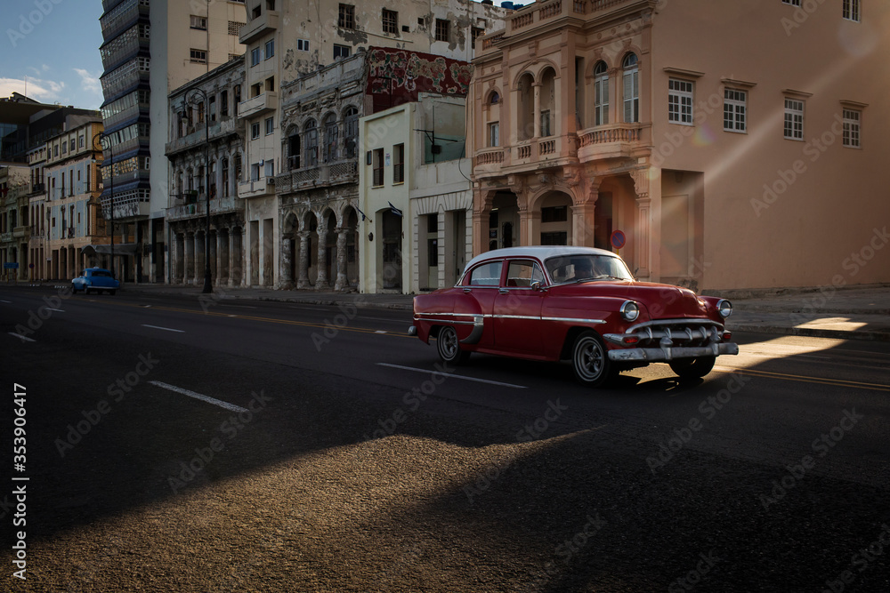 Old car on Malecon street of Havana with beautiful buildings in background. Cuba