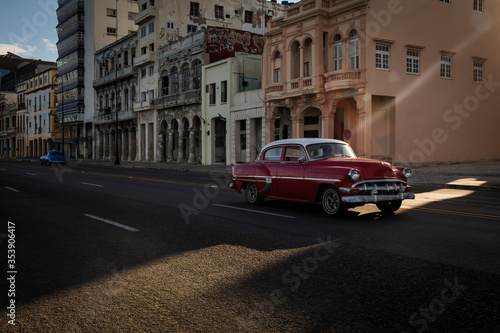 Old car on Malecon street of Havana with beautiful buildings in background. Cuba