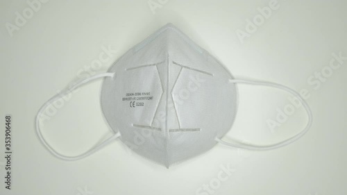 taking and wearing a White and clean new face mask protection against covid19  frontal view with hand