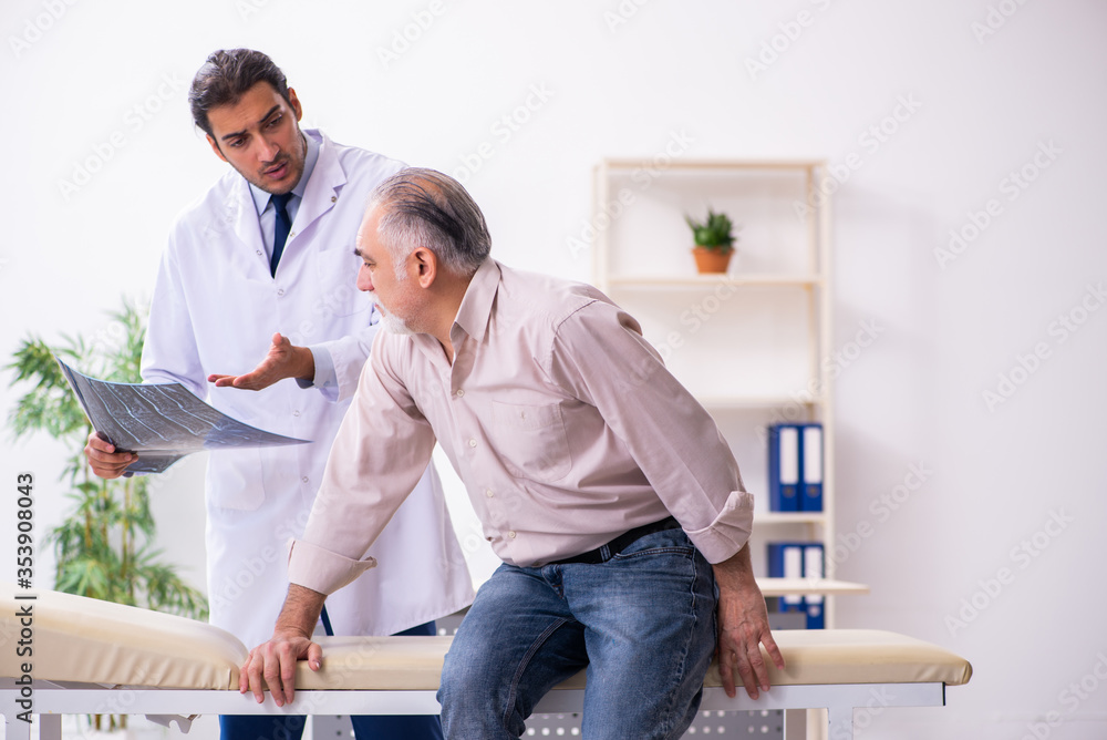 Fototapeta premium Old patient visiting young male doctor