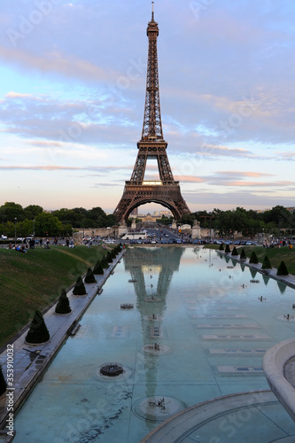 Eiffel tower with reflection in the water at the day time and night time