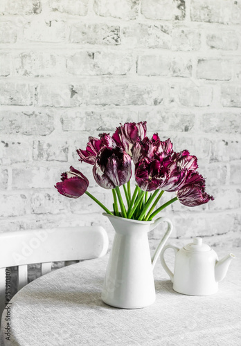 Bouquet of tulips on a table in a light kitchen room. Cozy home concept, copy space