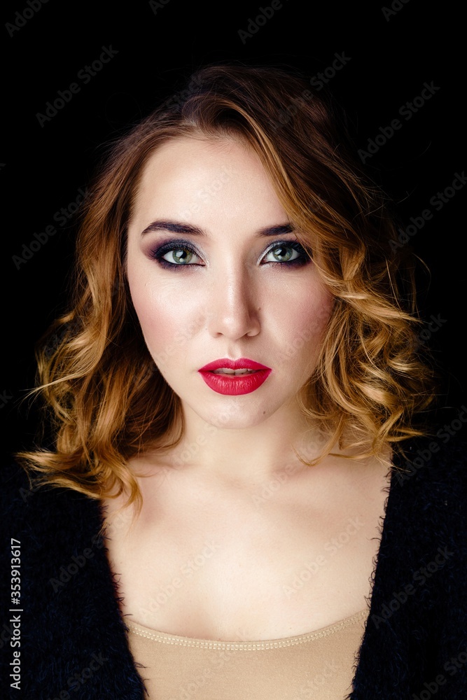Fototapeta premium Portrait of gorgeous young woman on dark background. Sensual young woman with red lips and bright makeup. Beautiful healthy face of the young pretty woman with fresh skin.