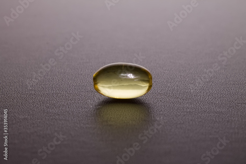 yellow translucent capsule lies on a dark background