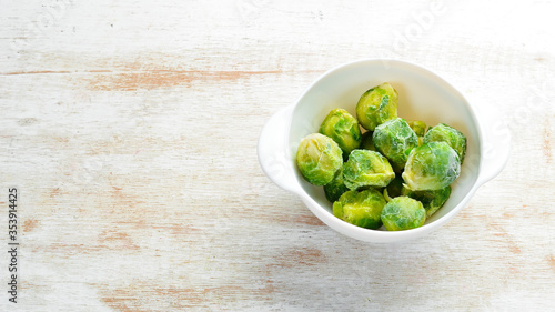 Frozen fresh green brussels sprouts. Food supplies. Top view. Free space for your text.
