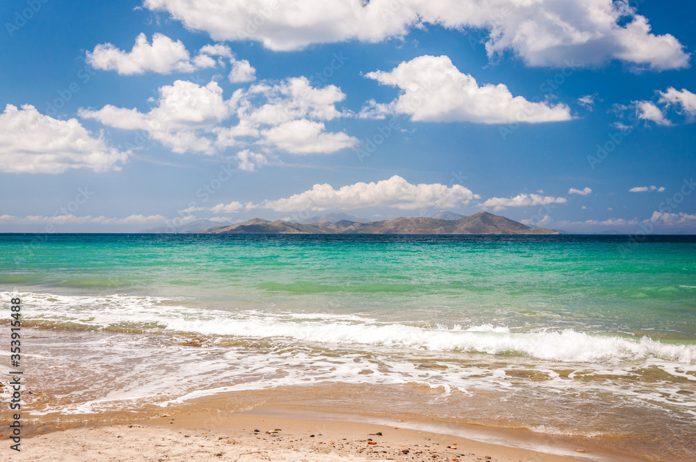 Beautiful golden sand beach with turquoise waters and a island and in the background. Kos island coast, Greece. Dodecanese islands. Beautiful golden sand beach with turquoise waters and a island and in the background. Kos island coast, Greece. Dodecanese islands.