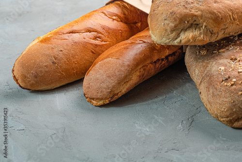 Fresh homemade crisp bread and baguettes close-up. Concept for banners, top view on a gray background.